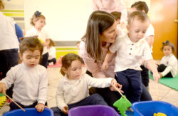 Maestra con tres ninos de educacion maternal